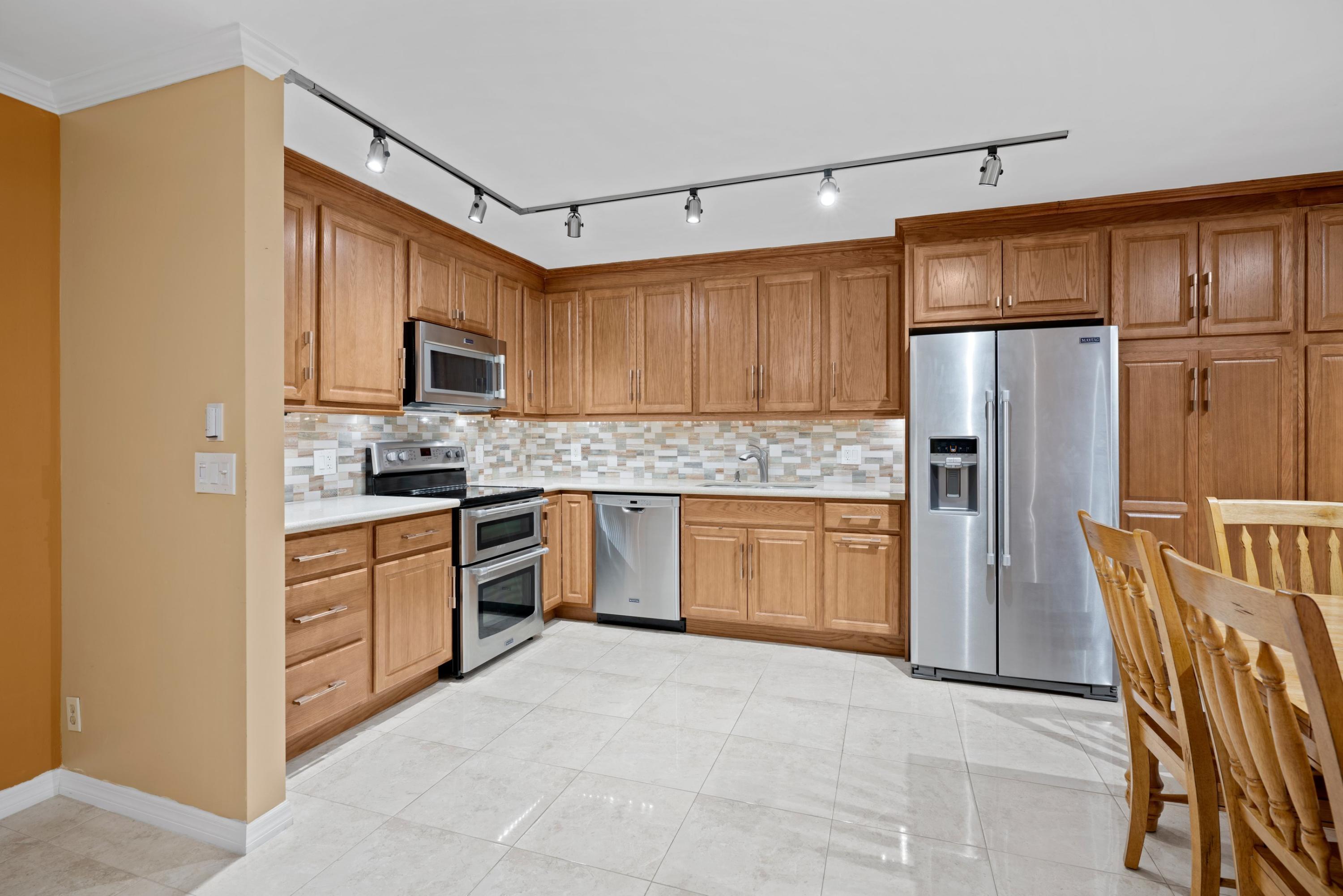 109 Woodland Road Palm Springs, FL 33461 - Photo 5 of 20 a kitchen with stainless steel appliances granite countertop a refrigerator stove top oven and sink