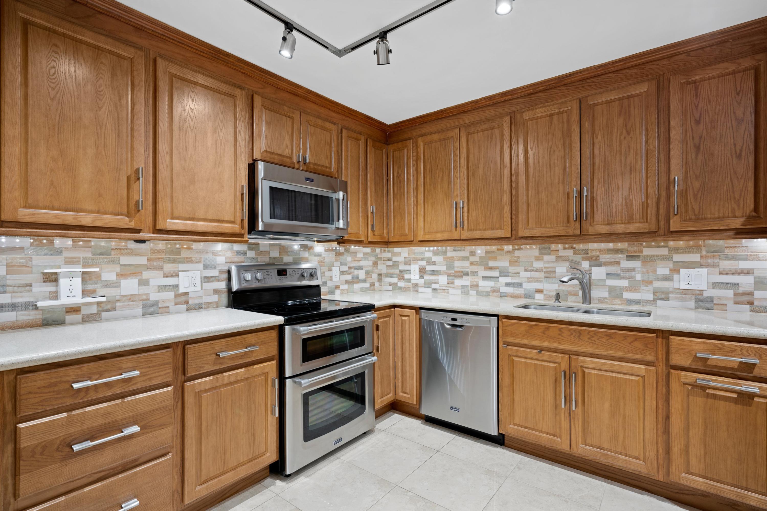 109 Woodland Road Palm Springs, FL 33461 - Photo 6 of 20 a kitchen with white cabinets sink and stainless steel appliances