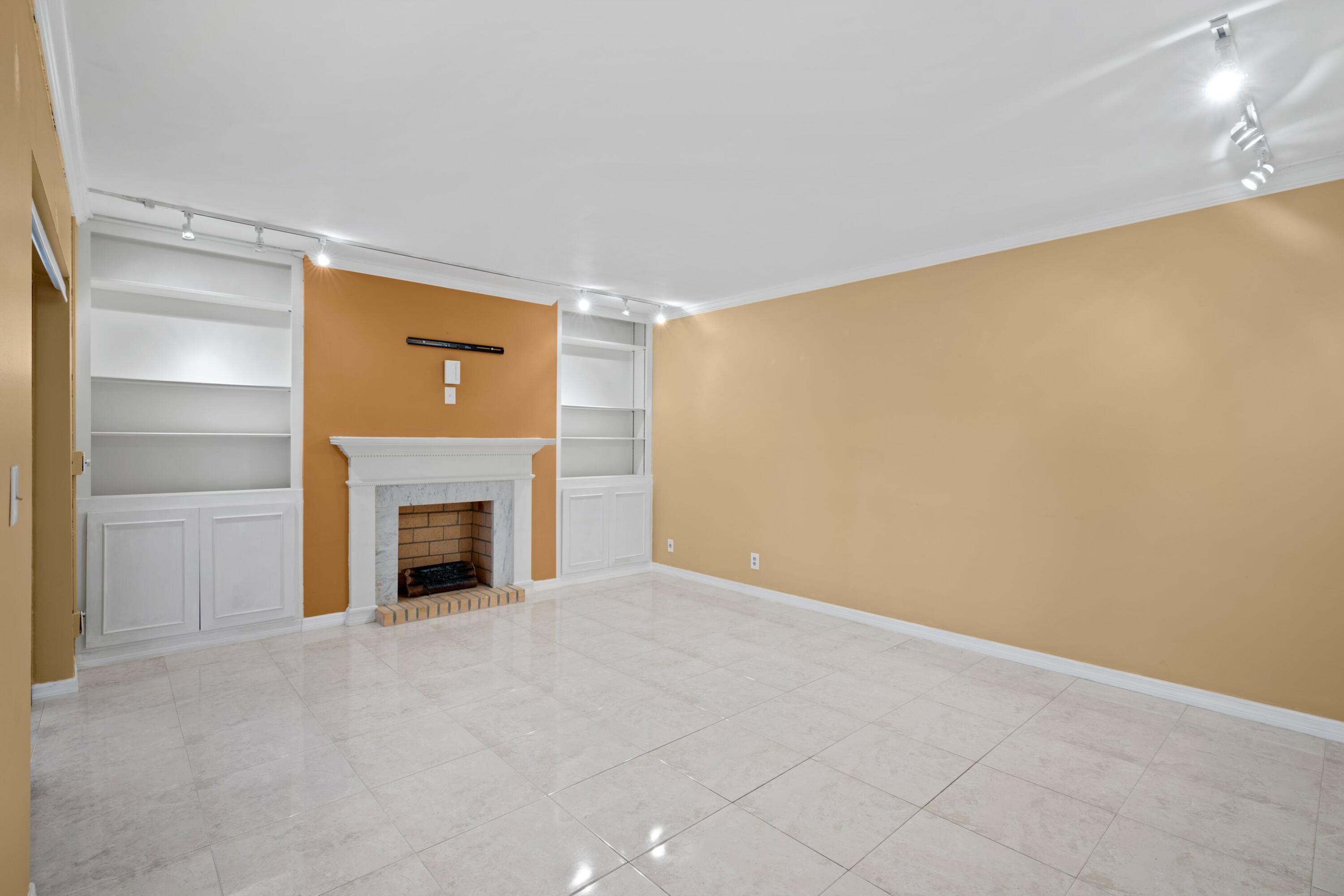 109 Woodland Road Palm Springs, FL 33461 - Photo 9 of 20 a view of an empty room with a fireplace and a window