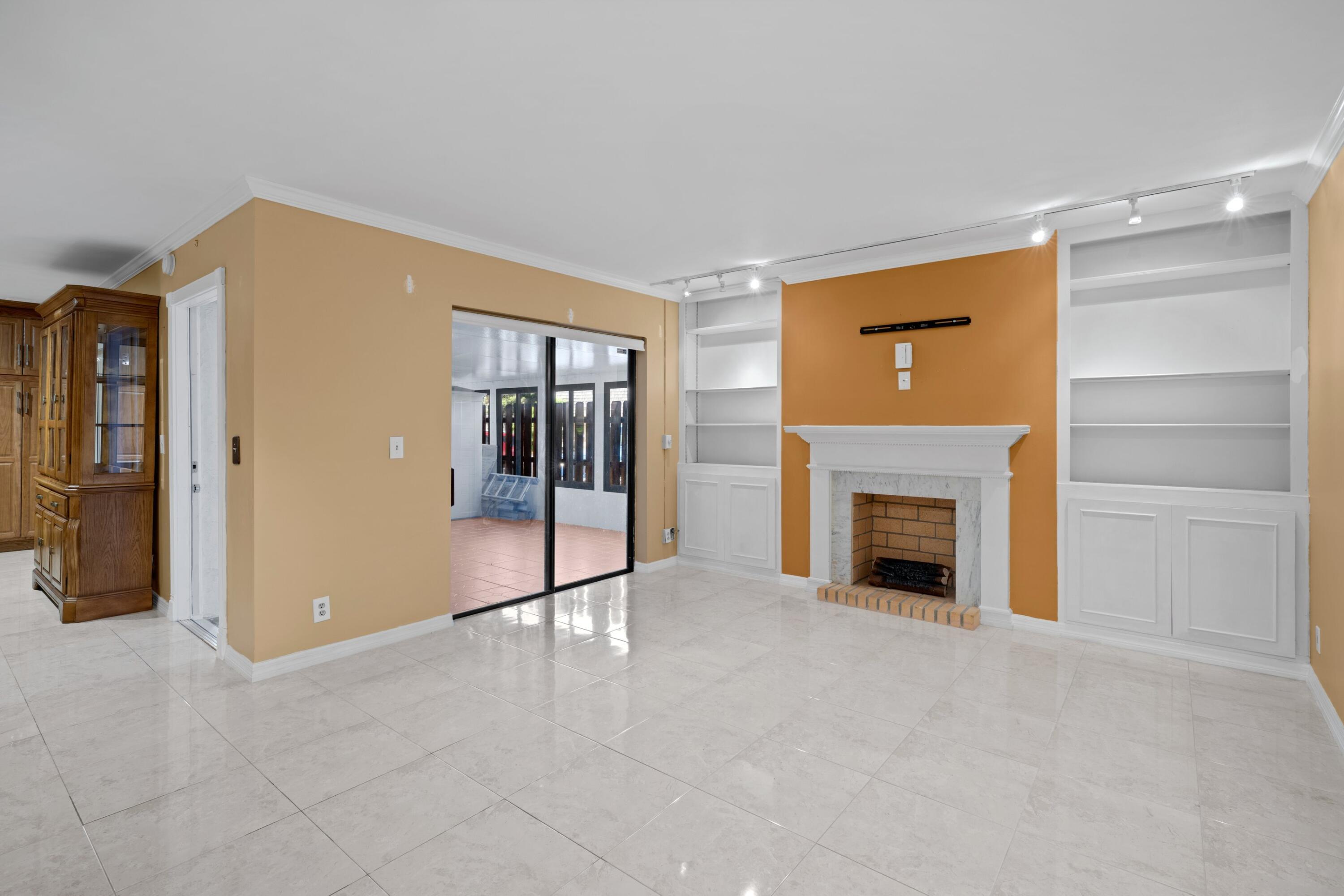 109 Woodland Road Palm Springs, FL 33461 - Photo 10 of 20 a view of an empty room with a fireplace and a window