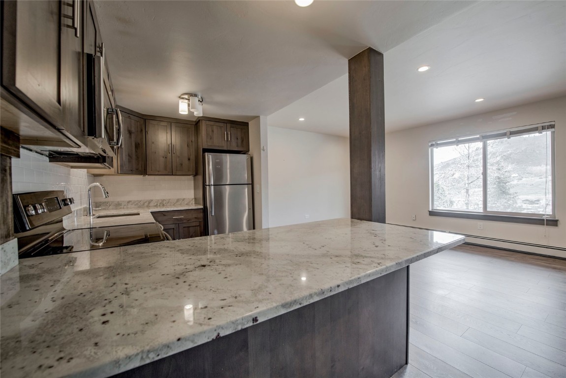 150 Evergreen Road, Unit 106 Dillon, CO 80435 - Photo 3 of 19 a kitchen with stainless steel appliances granite countertop a sink and a stove