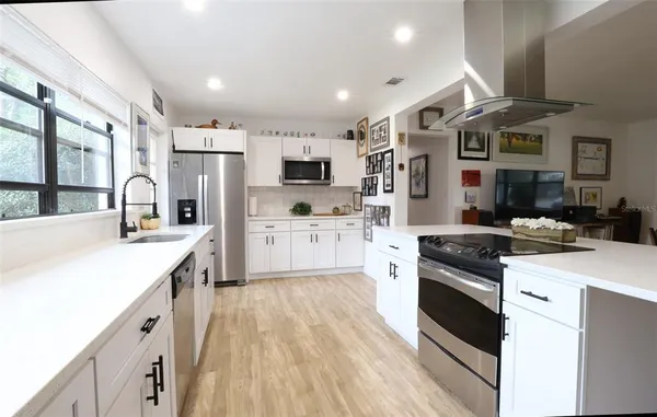 a kitchen with stainless steel appliances white cabinets and a refrigerator