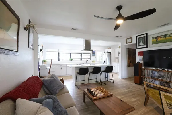 a kitchen with stainless steel appliances granite countertop table chairs cabinets and wooden floor
