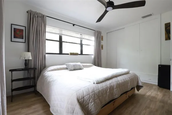 a bedroom with a bed next to a window