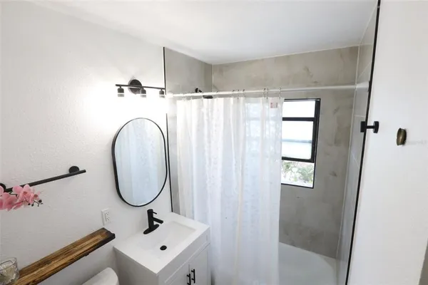 a bathroom with a sink mirror and tub