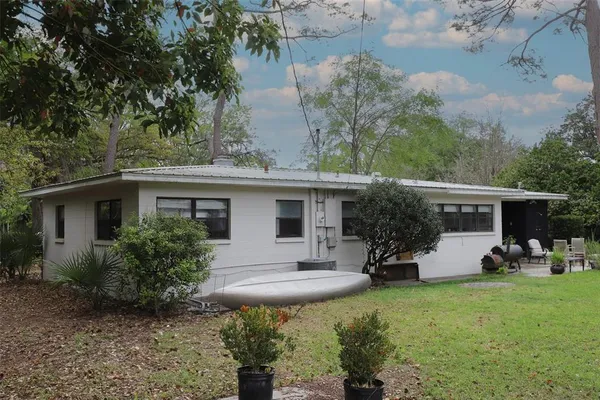 a view of a house with backyard sitting area and garden