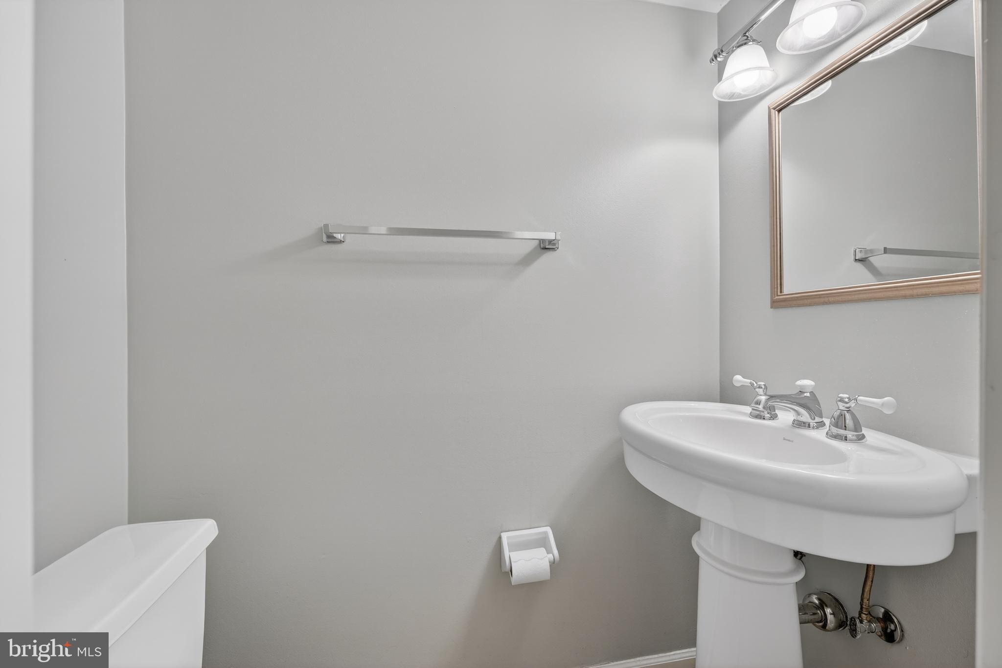 8139 Carrleigh Parkway Springfield, VA 22152 - Photo 6 of 27 a bathroom with a sink a toilet and mirror