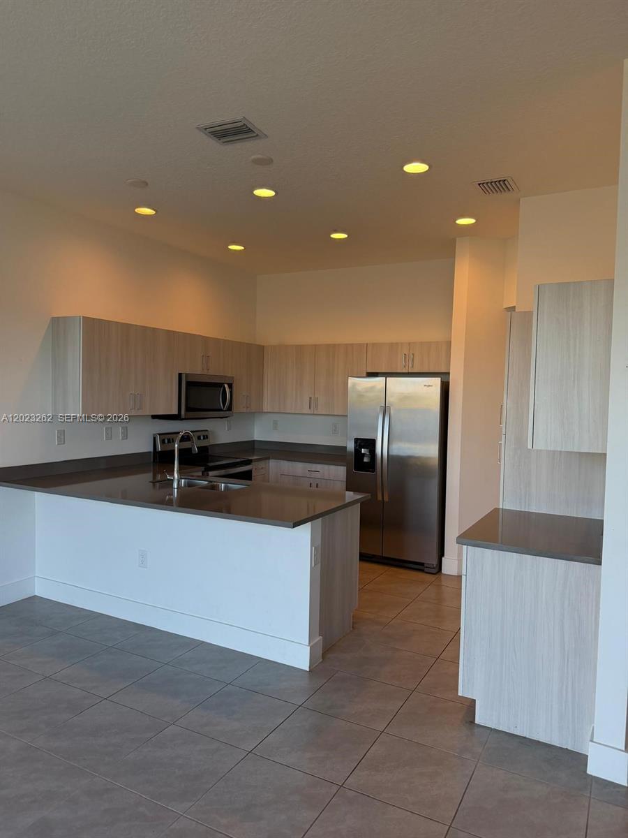 5669 Cerva Lane, Unit 5669 Immokalee, FL 34142 - Photo 25 of 32 a kitchen with stainless steel appliances a refrigerator and a sink