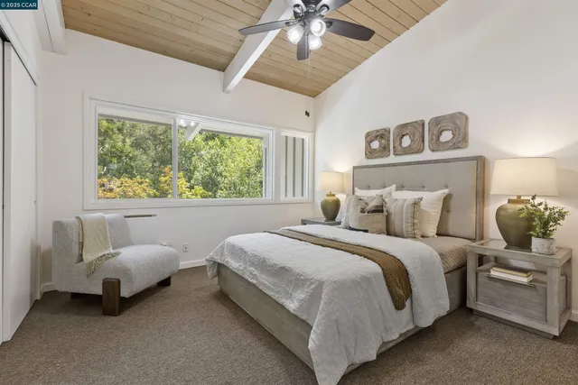a bedroom with a bed couches chair and a large window