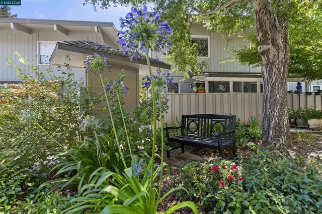 a view of a house with wooden fence and garden