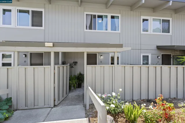 a view of a house with a small yard and wooden fence