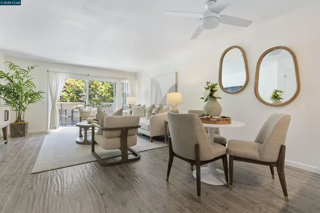 a dining room with furniture a large window and wooden floor