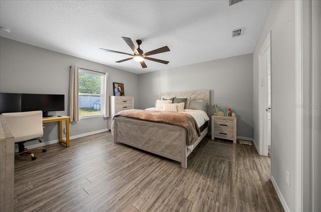 13 Teak Loop Place Ocala, FL 34472 - Photo 27 of 36 a bedroom with a bed and a chandelier