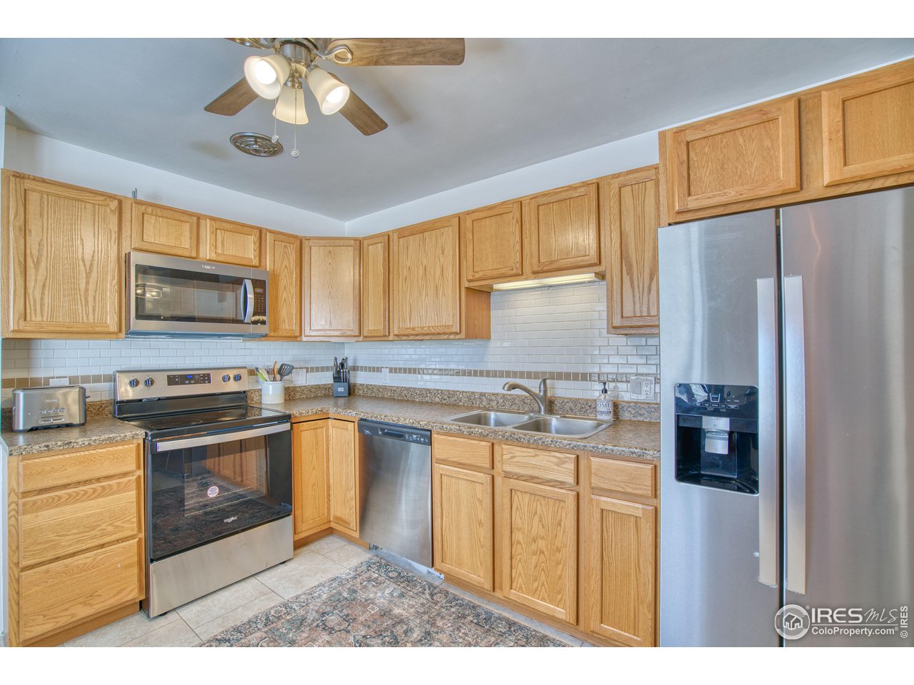 101 6th Street Frederick, CO 80530 - Photo 12 of 35 a kitchen with stainless steel appliances granite countertop a stove a sink dishwasher a refrigerator and a microwave