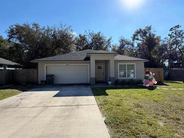 a view of a house with backyard and trees