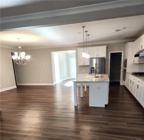 a kitchen with a sink cabinets and wooden floor