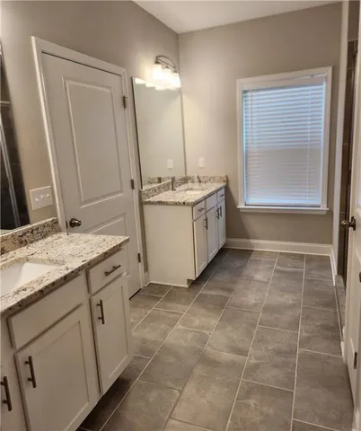 a bathroom with a granite countertop sink a toilet and a mirror
