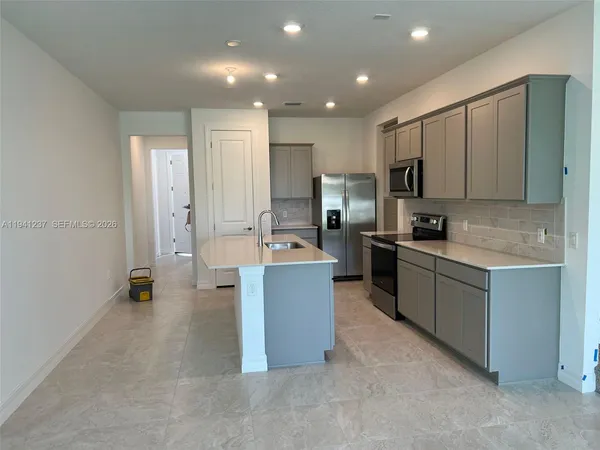 a large kitchen with a large counter top appliances and cabinets