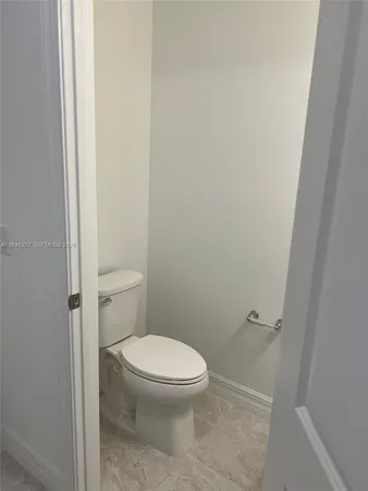 a white toilet sitting next to a shower
