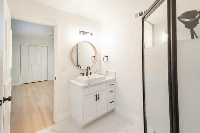 a bathroom with a sink a mirror and shower