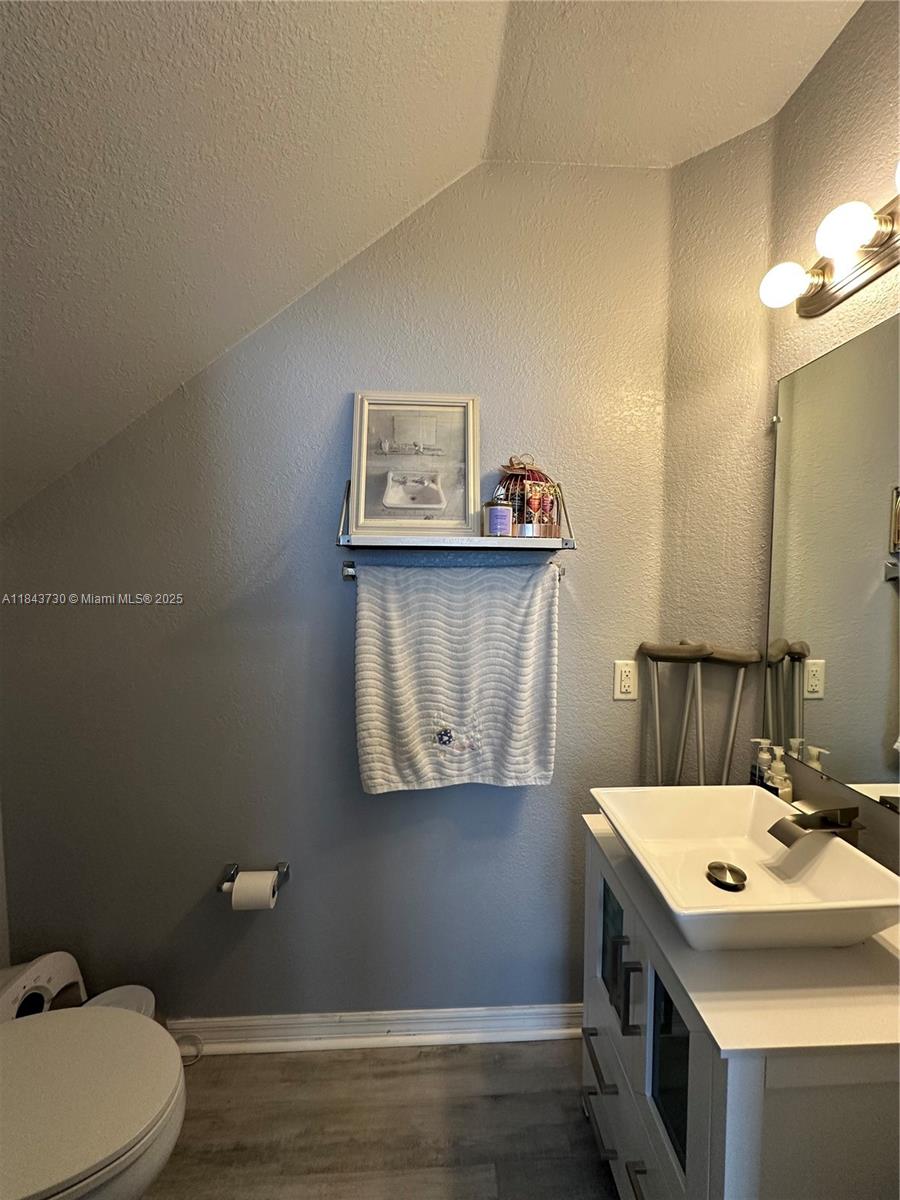 141 Northwest 2nd Avenue, Unit 2 Hallandale Beach, FL 33009 - Photo 8 of 21 a bathroom with a sink mirror and toilet
