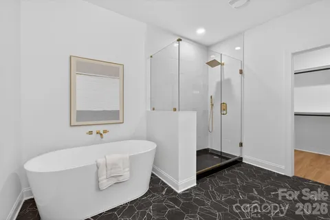 a spacious bathroom with a tub shower and a sink