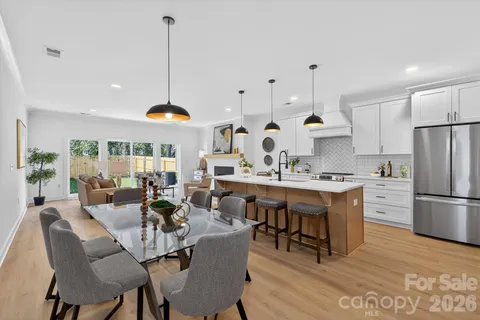 a dining room filled chandelier and wooden furniture