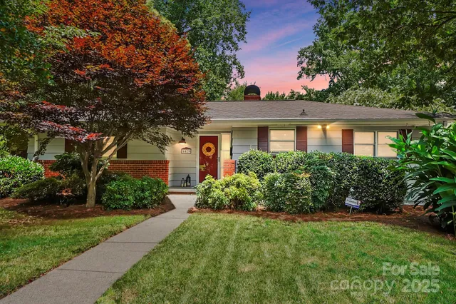 a front view of a house with a yard and potted plants