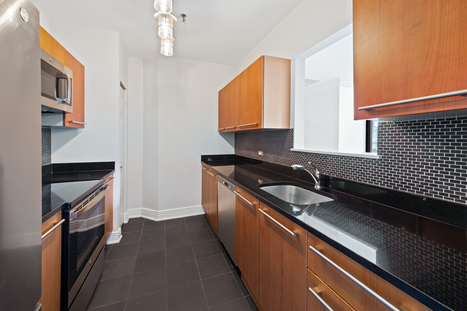 780 South Federal Street, Unit 407 Chicago, IL 60605 - Photo 11 of 20 a kitchen with granite countertop stainless steel appliances a sink stove top oven and cabinets