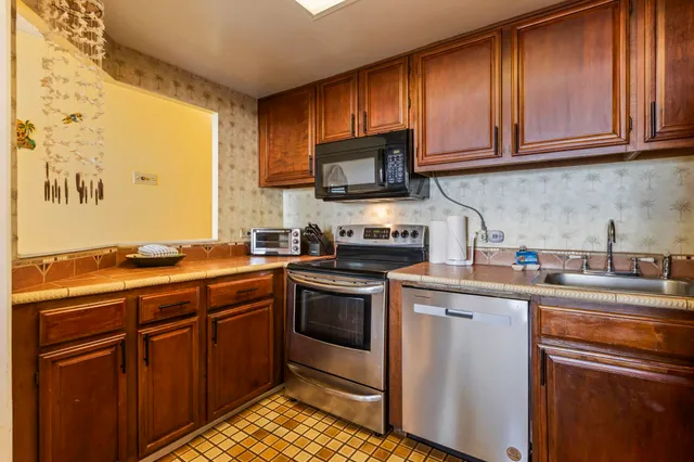 a kitchen with stainless steel appliances granite countertop a stove refrigerator and cabinets