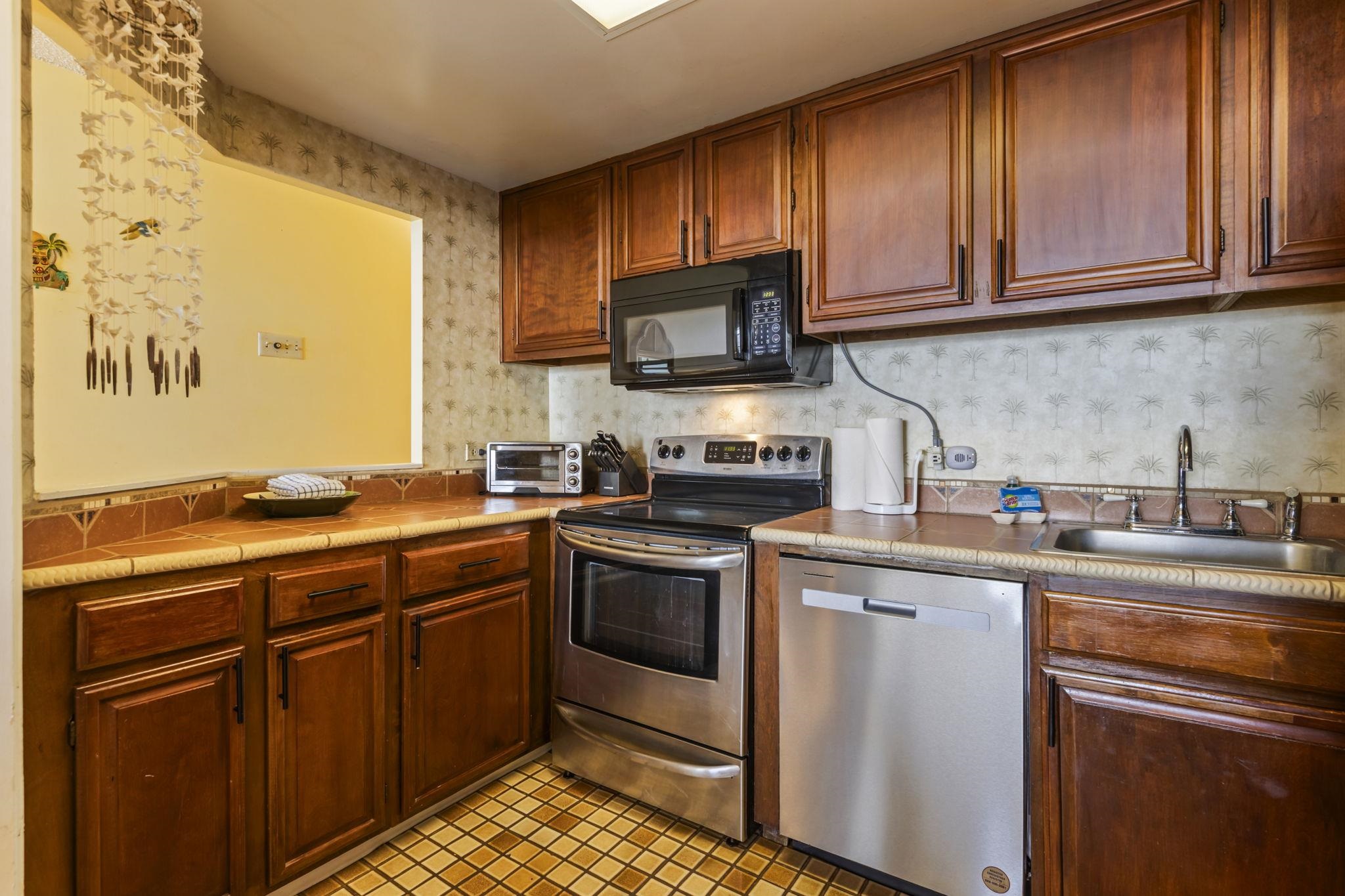3875 Lower Honoapiilani Road, Unit B205 Lahaina, HI 96761 - Photo 8 of 28 a kitchen with stainless steel appliances granite countertop a sink stove and microwave