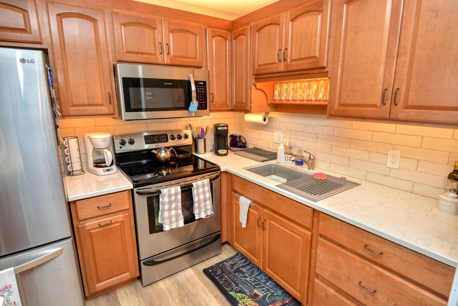 1225 Northwest 21st Street, Unit 2602 Stuart, FL 34994 - Photo 5 of 24 a kitchen with stainless steel appliances granite countertop a sink stove and microwave