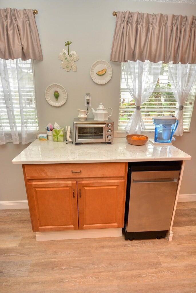 1225 Northwest 21st Street, Unit 2602 Stuart, FL 34994 - Photo 6 of 24 a kitchen with stainless steel appliances granite countertop a sink a microwave cabinets and a dining table