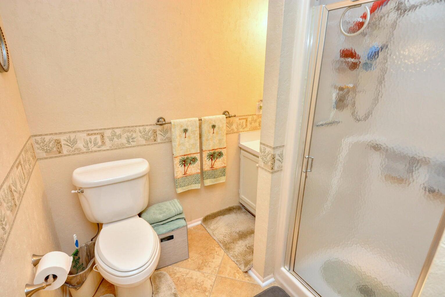 1225 Northwest 21st Street, Unit 2602 Stuart, FL 34994 - Photo 10 of 24 a white toilet sitting next to a bathroom sink