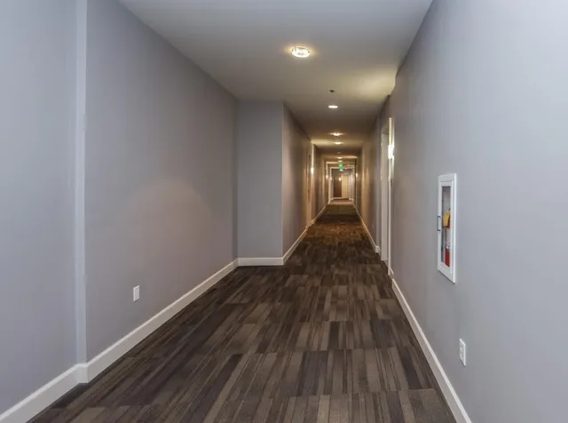 a view of a hallway with wooden floor