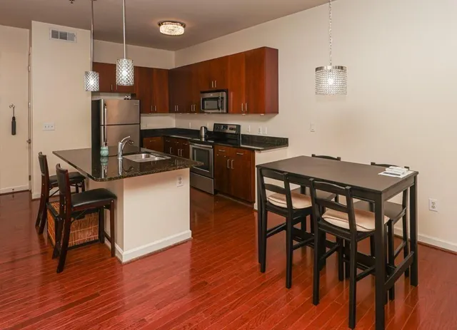 a kitchen with stainless steel appliances wooden floors and wooden cabinets