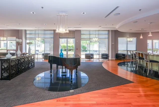 a view of a dining room with furniture a chandelier and kitchen view