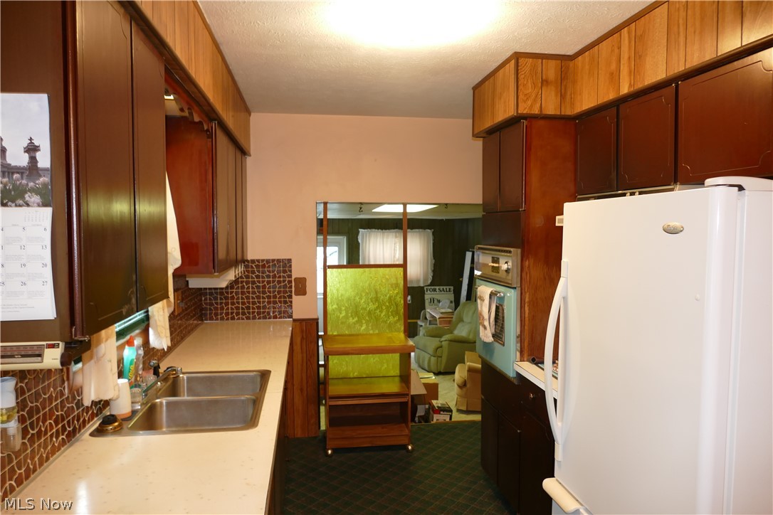 8661 Ravenna Road Chardon, OH 44024 - Photo 12 of 16 Kitchen with tasteful backsplash, white fridge, and sink