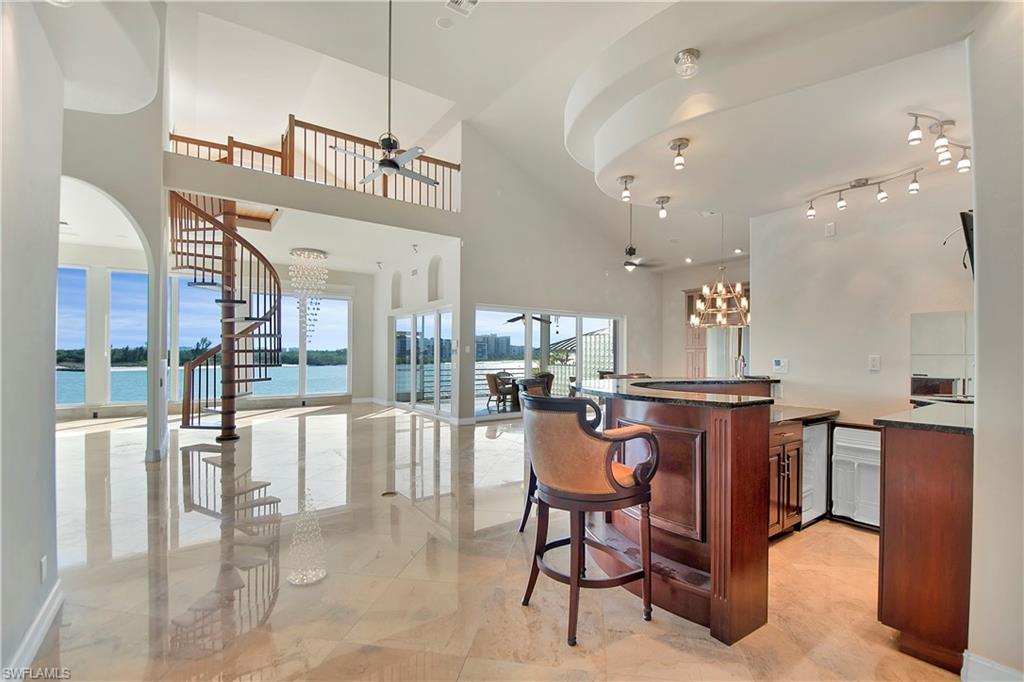 28 West Pelican Street Naples, FL 34113 - Photo 17 of 50 a dinning area with stainless steel appliances kitchen island granite countertop a table and chairs