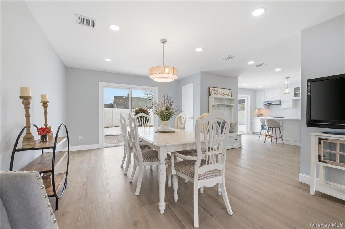 89 Ridge Lane Levittown, NY 11756 - Photo 10 of 44 a view of a dining room with furniture and a flat screen tv