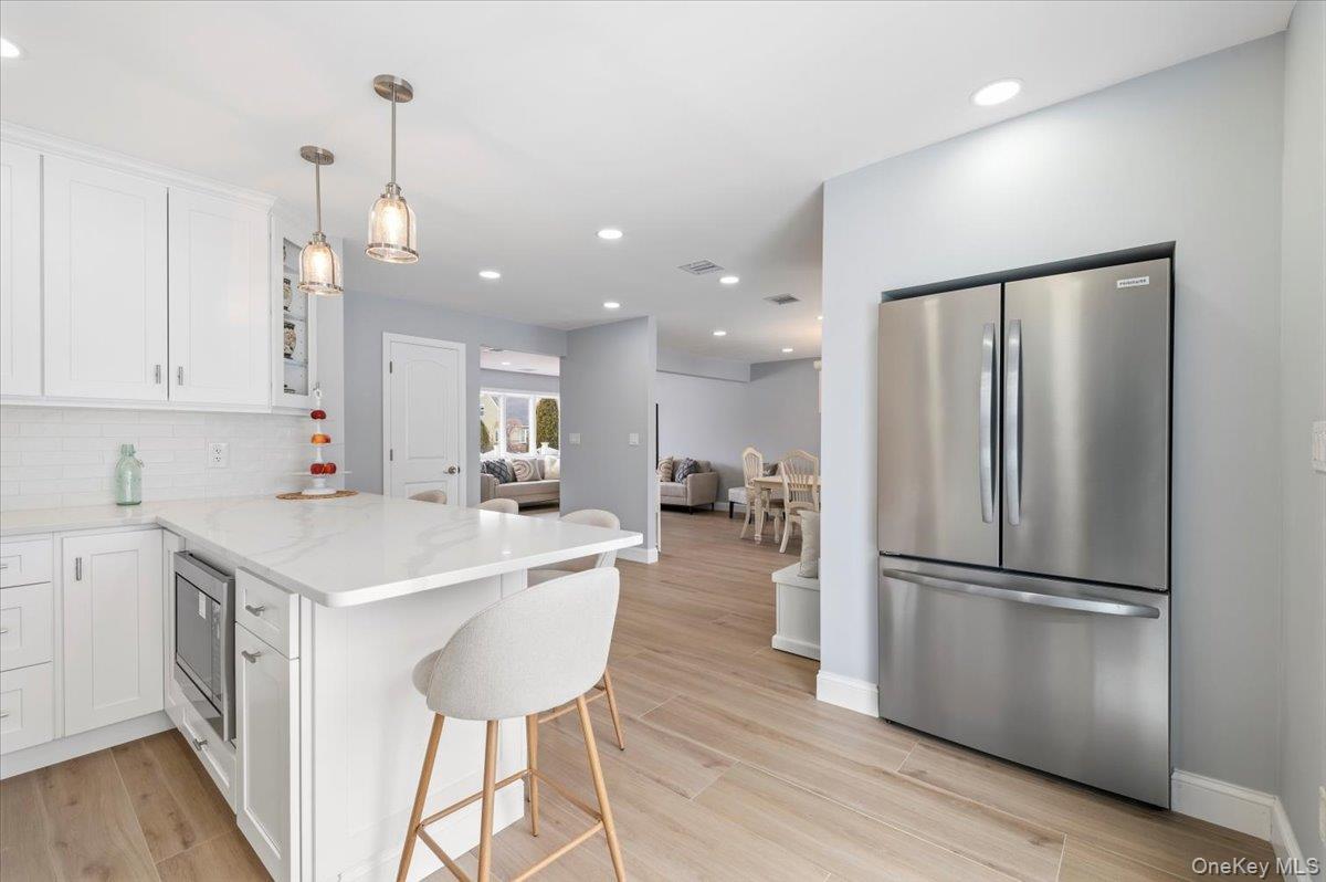 89 Ridge Lane Levittown, NY 11756 - Photo 14 of 44 a kitchen with a refrigerator a sink and a stove top oven