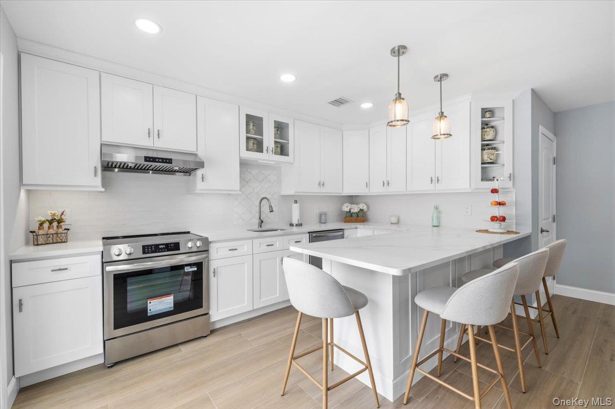 89 Ridge Lane Levittown, NY 11756 - Photo 15 of 44 a kitchen with granite countertop white cabinets and white appliances