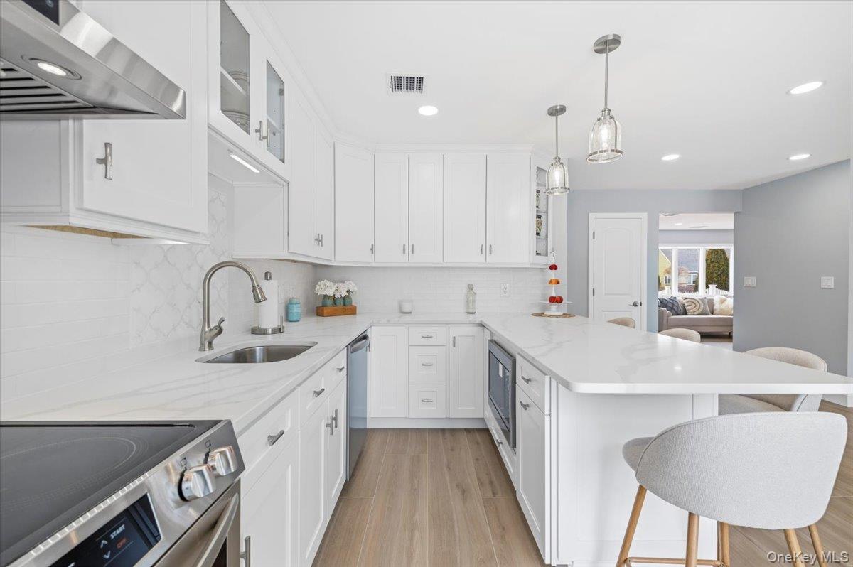 89 Ridge Lane Levittown, NY 11756 - Photo 17 of 44 a kitchen with a sink a stove and cabinets