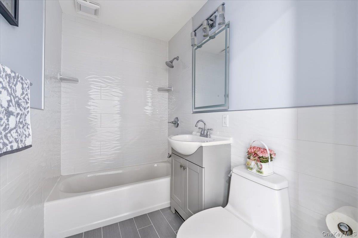89 Ridge Lane Levittown, NY 11756 - Photo 21 of 44 a bathroom with a sink toilet and shower