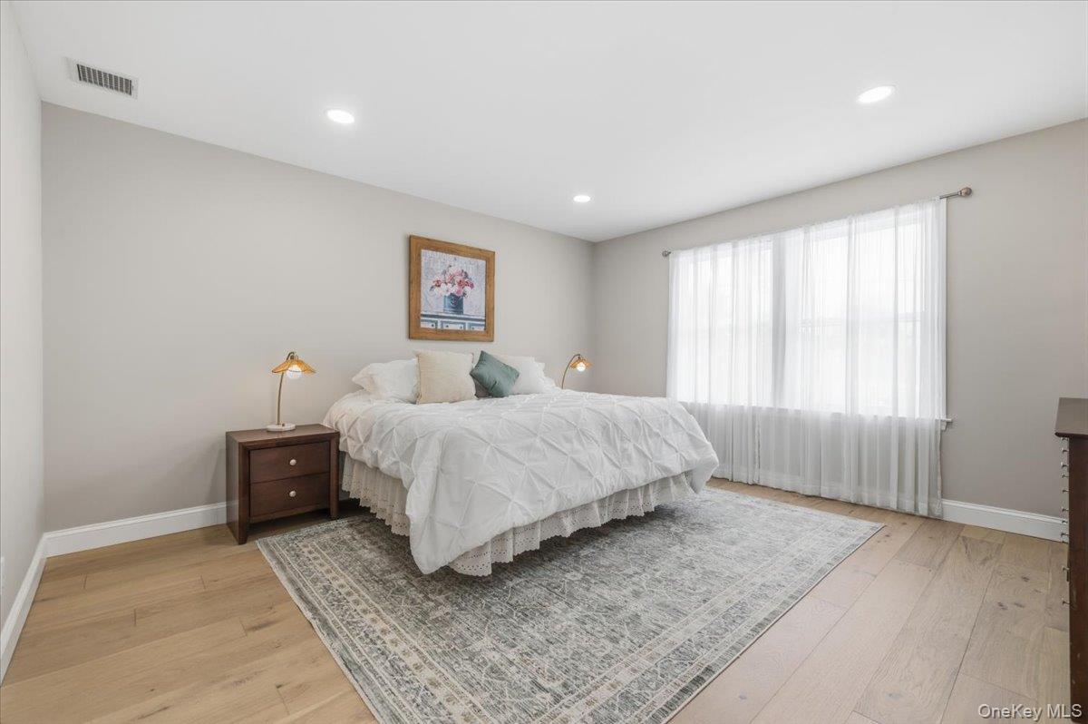 89 Ridge Lane Levittown, NY 11756 - Photo 23 of 44 a bedroom with a bed and a large window