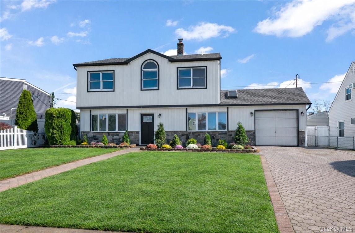 89 Ridge Lane Levittown, NY 11756 - Photo 3 of 44 a front view of a house with a yard and garage