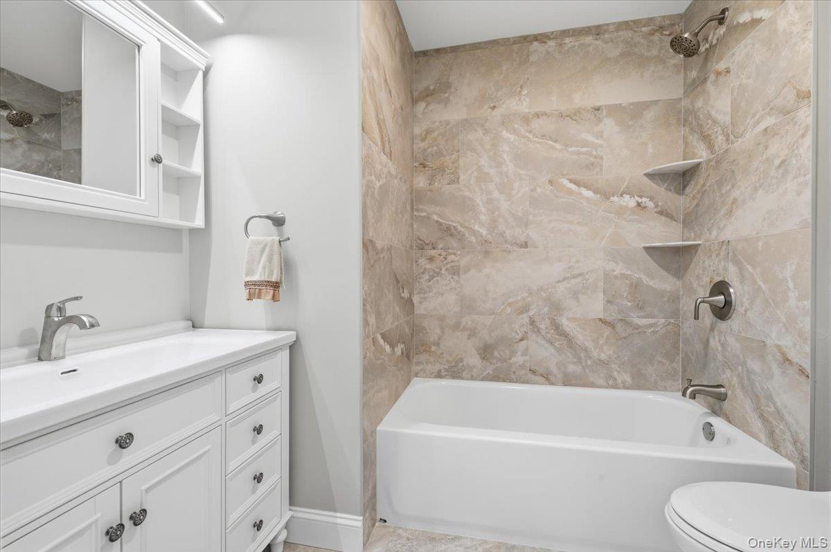 89 Ridge Lane Levittown, NY 11756 - Photo 29 of 44 a bathroom with a sink a toilet and a bathtub