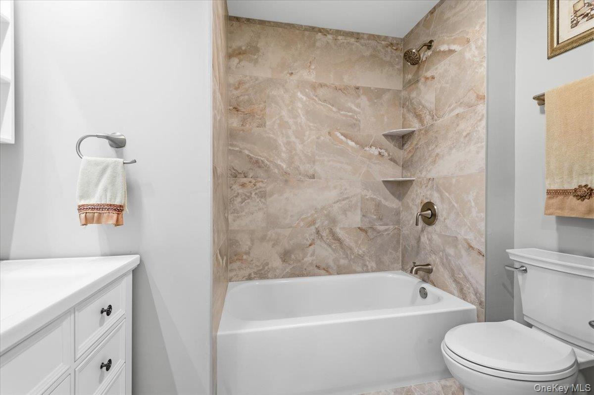 89 Ridge Lane Levittown, NY 11756 - Photo 30 of 44 a white bath tub sitting next to a white toilet and sink