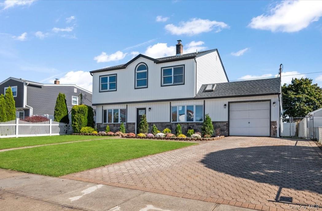 89 Ridge Lane Levittown, NY 11756 - Photo 5 of 44 a front view of a house with a yard and garage