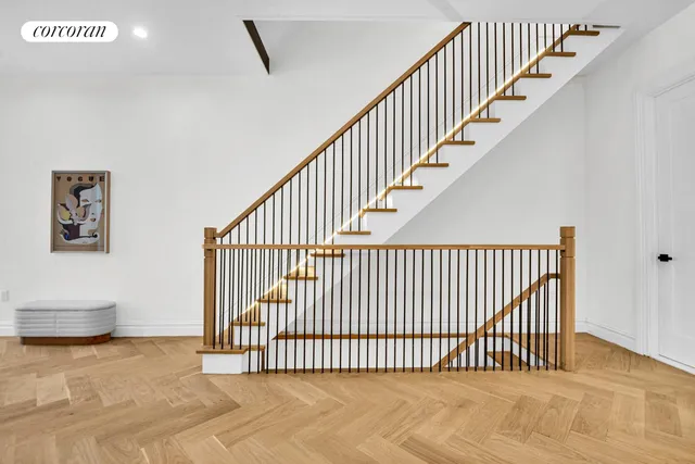 a view of staircase with railing and white walls